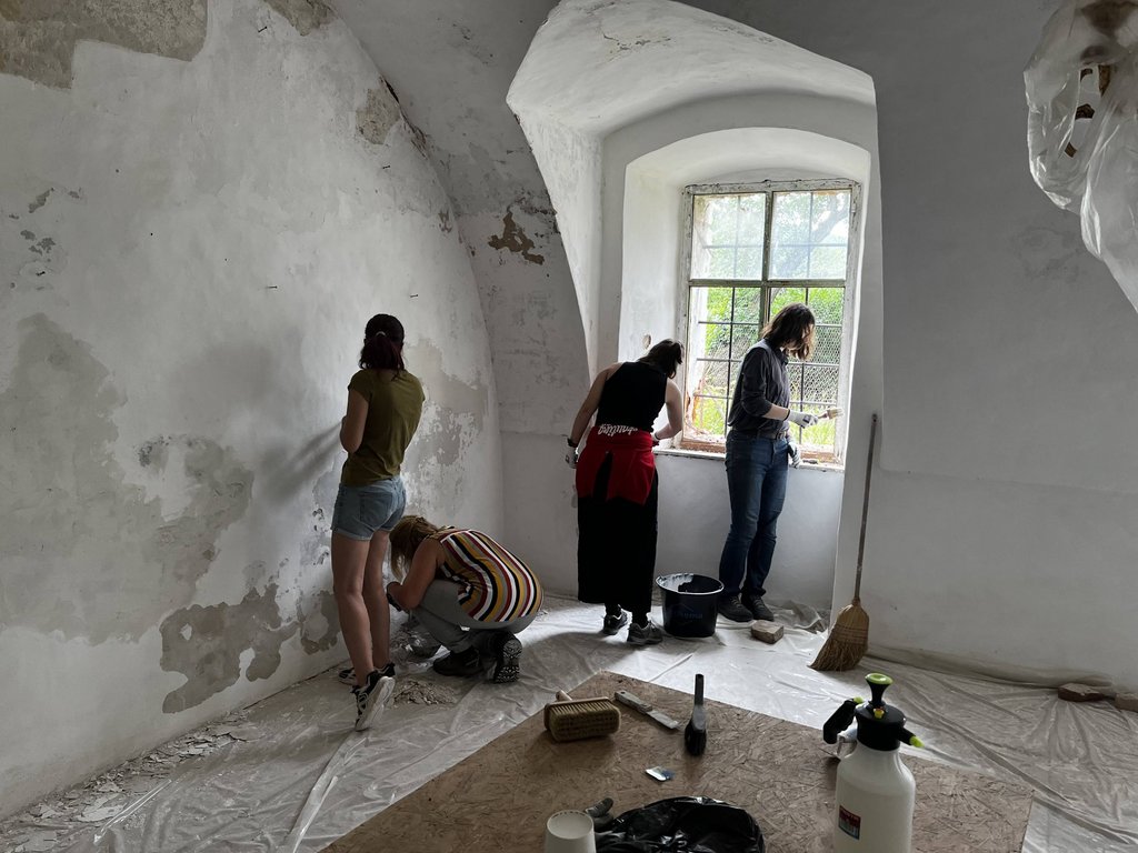 Študenti pri oprave omietky počas workshopu, Zdroj: KPÚ Nitra (Foto: P. Sater)