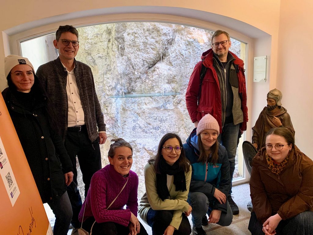 Spoločná fotografia členov Medzinárodnej riadiacej skupiny Dunajský Limes (západ) pred rímskym nápisom na hradnej skale v Trenčíne, archív E. Makarovej