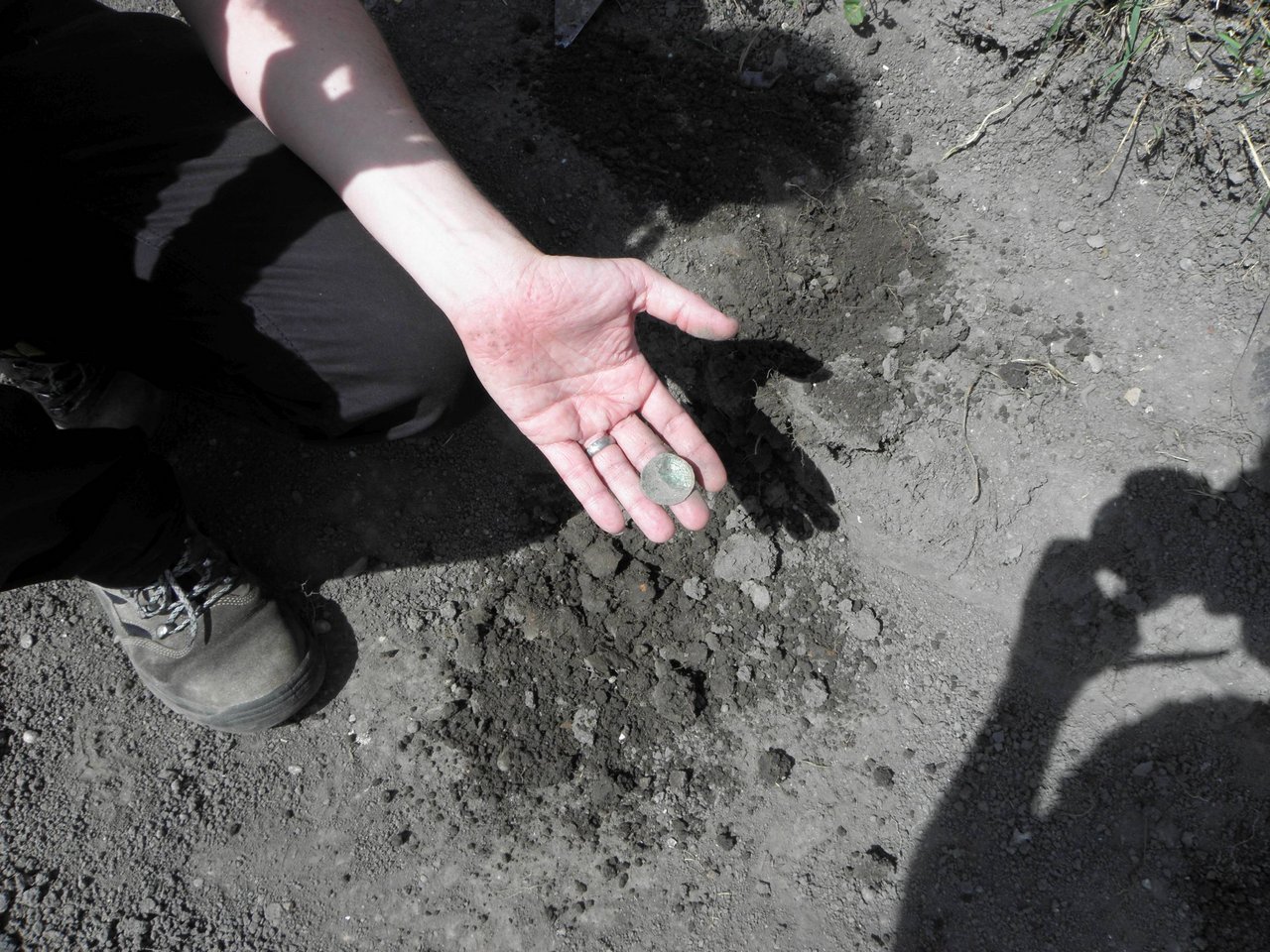 Vyzdvihnutá minca z výkopu pre bazén počas archeologického výskumu miesta nálezu, zdroj: KPÚ Trnava, foto: M. Sládok