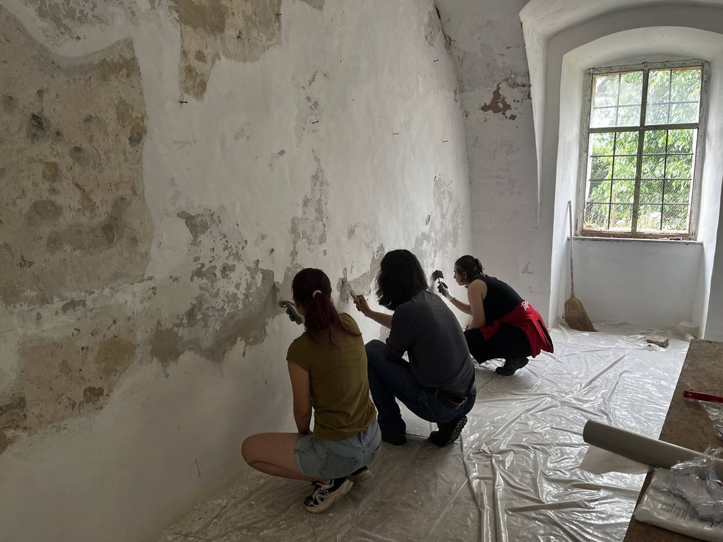Študenti pri oprave omietky počas workshopu, Zdroj: KPÚ Nitra (Foto: P. Sater)