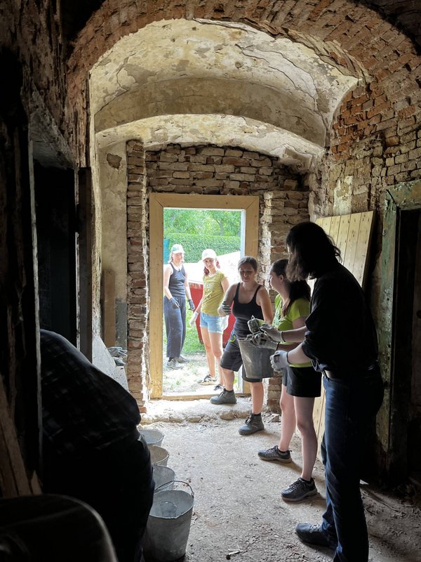 Študenti a zamestnanci KPÚ Nitra pri odstraňovaní sutiny počas workshopu, Zdroj: KPÚ Nitra (Foto: Z. Holičková) 